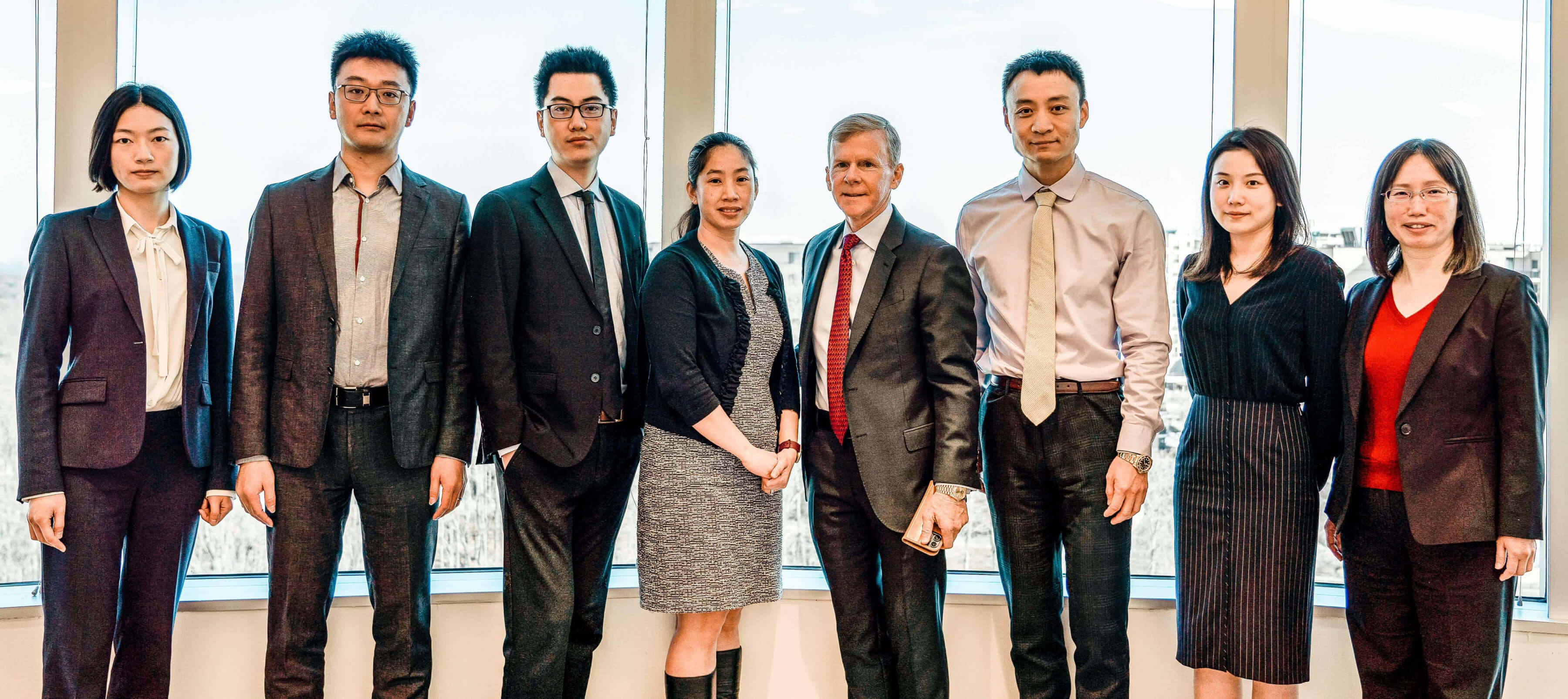 An image of the management team of SLCG Economic Consulting posing in the office conference room.