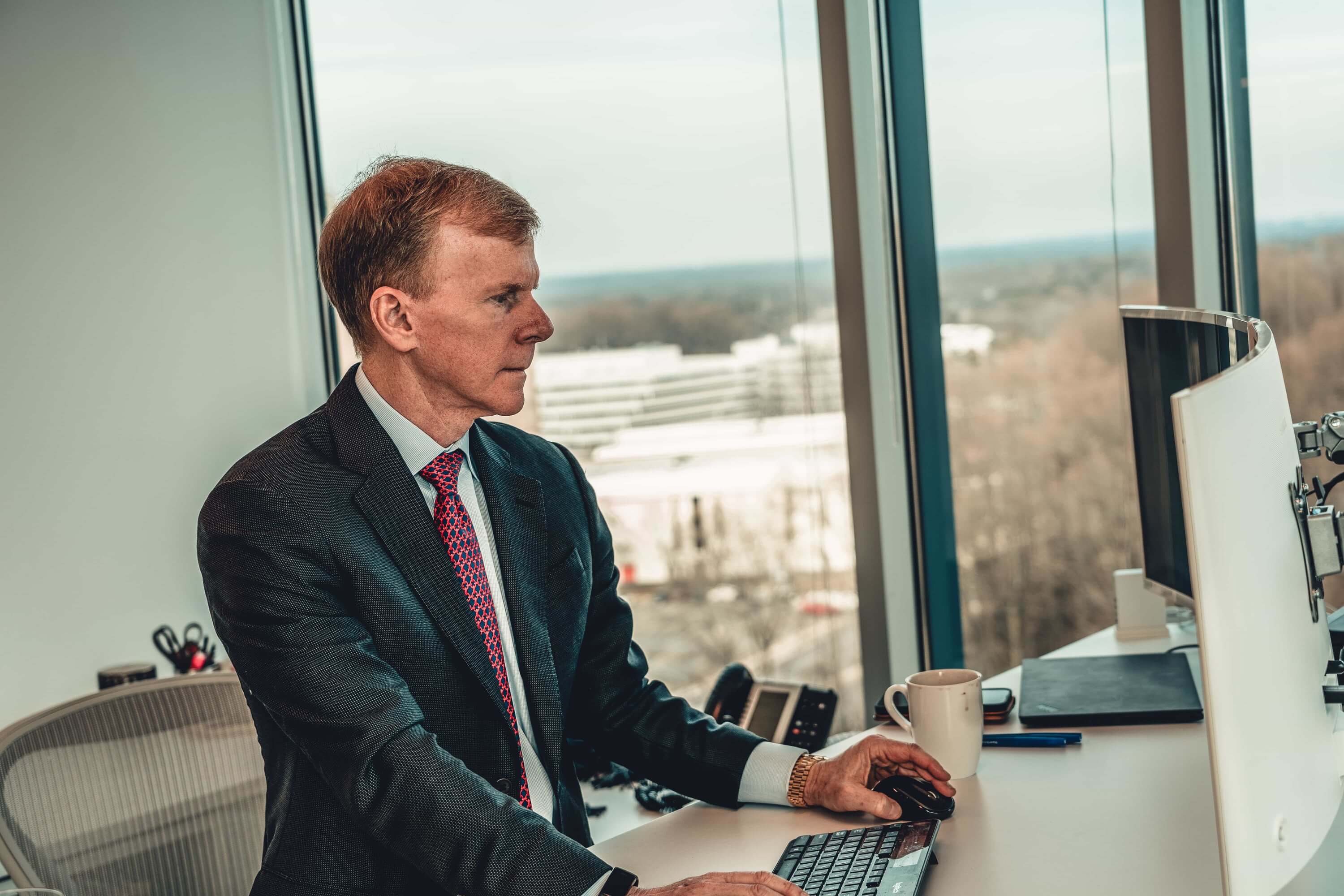 A photo of SLCG Economic Consulting Founder and Principal, Craig McCann, hard at work at his desk.