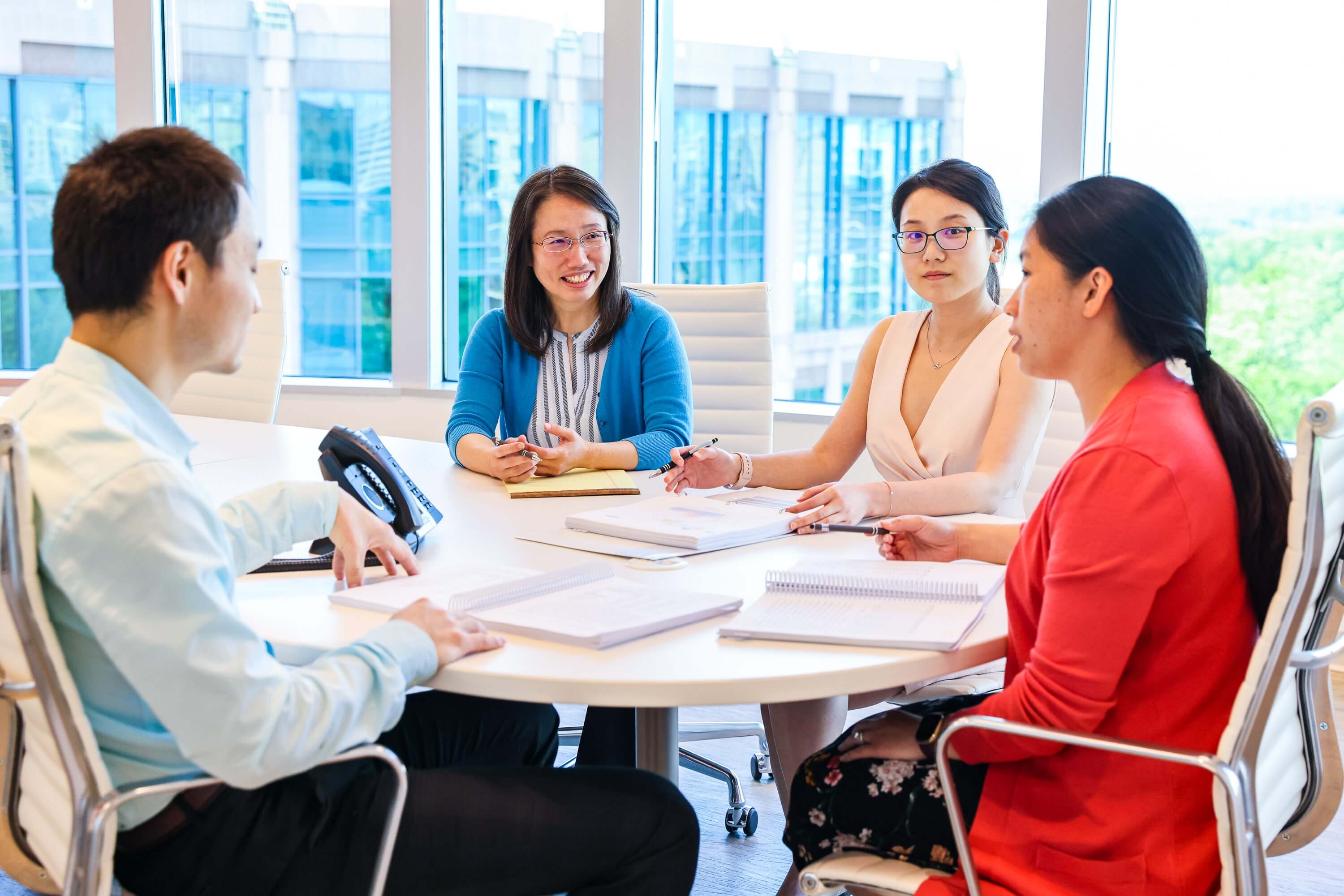 A photo of members of the SLCG Economic Consulting team having a meeting in the conference room.